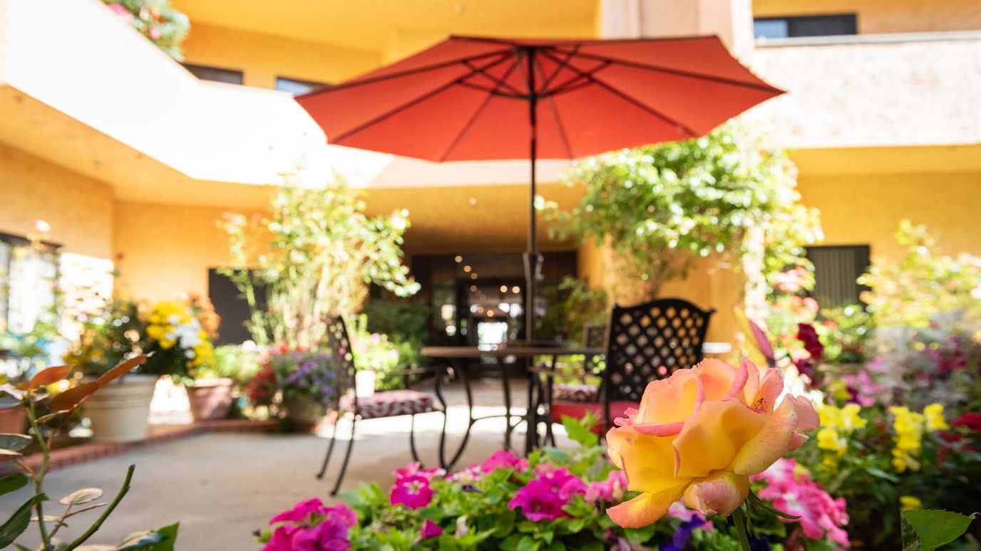 Outdoor space with flowers and an umbrella table