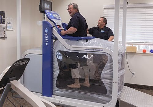 Residents using an anti-gravity treadmill during therapy session