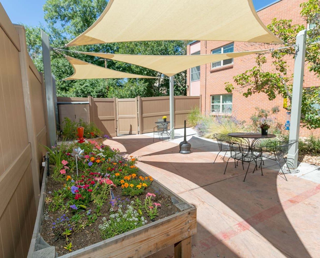Outdoor patio area with shaded seating and flowers