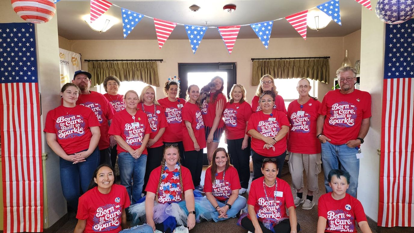 Staff and residents in matching shirts at a celebration