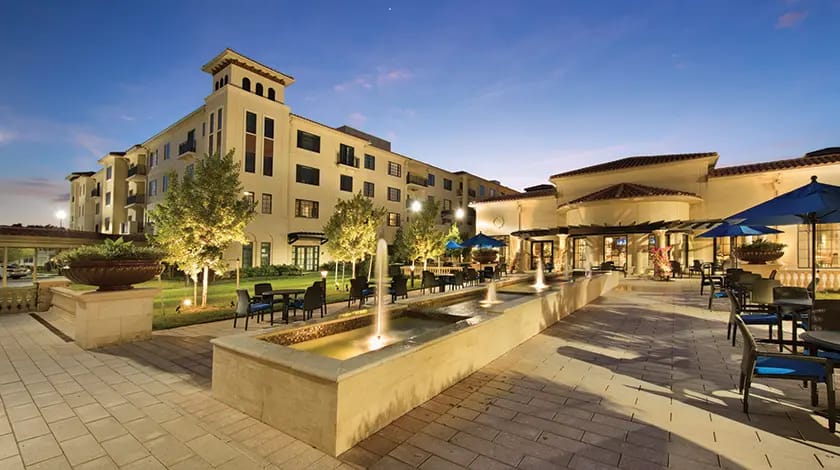 Exterior view of a senior living facility at dusk.
