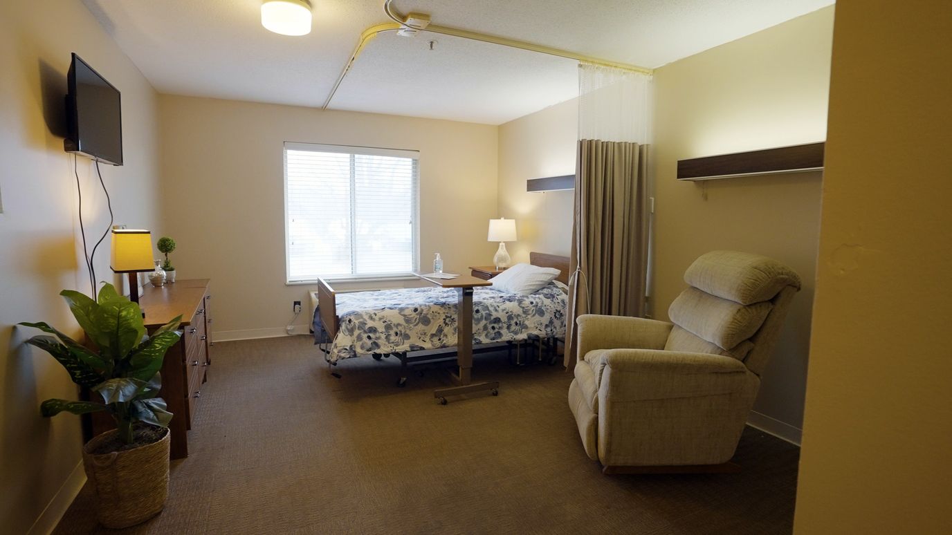 A well-furnished private resident room with a bed and seating area