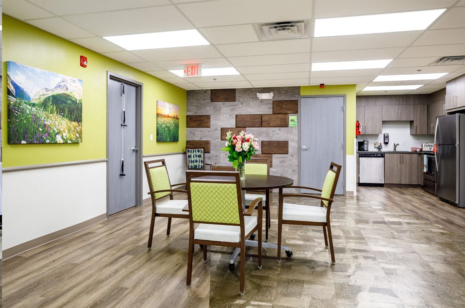 Bright, inviting common area with artwork and kitchen