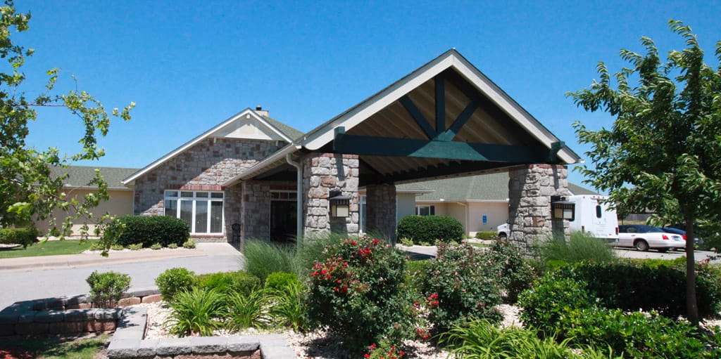 Exterior view of assisted living facility with flowers and green space