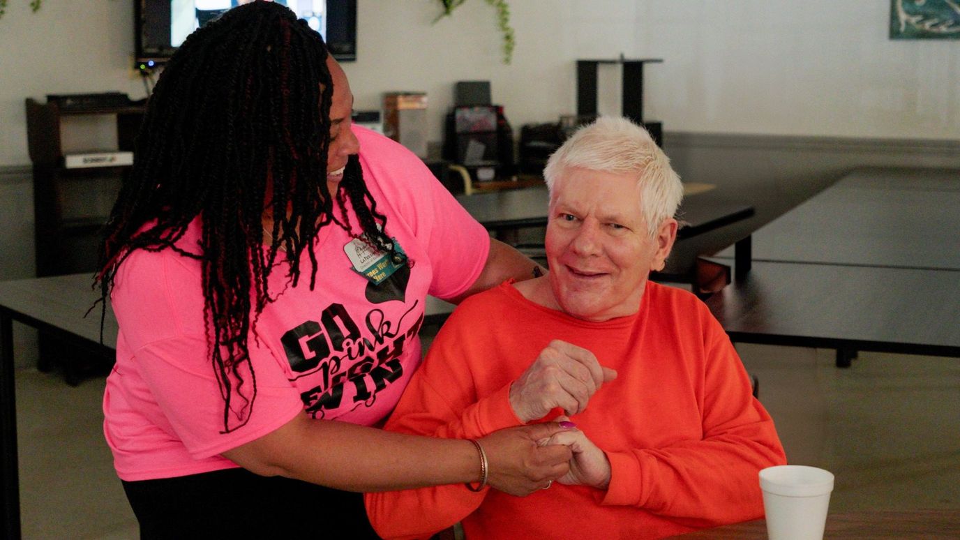 Chapel Woods Health and Rehabilitation, Nursing Home in Warren, AR — Staff member assisting a resident with a smile