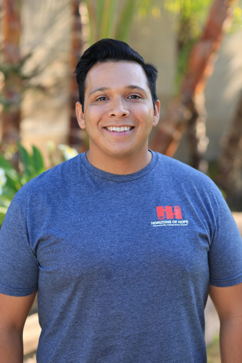 Staff member smiling in a garden area