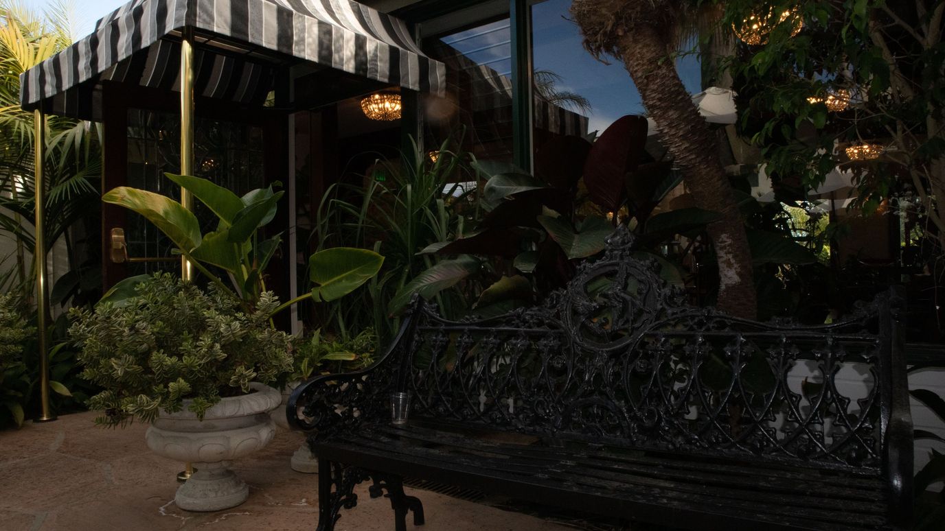 Outdoor seating area with plants near building entrance