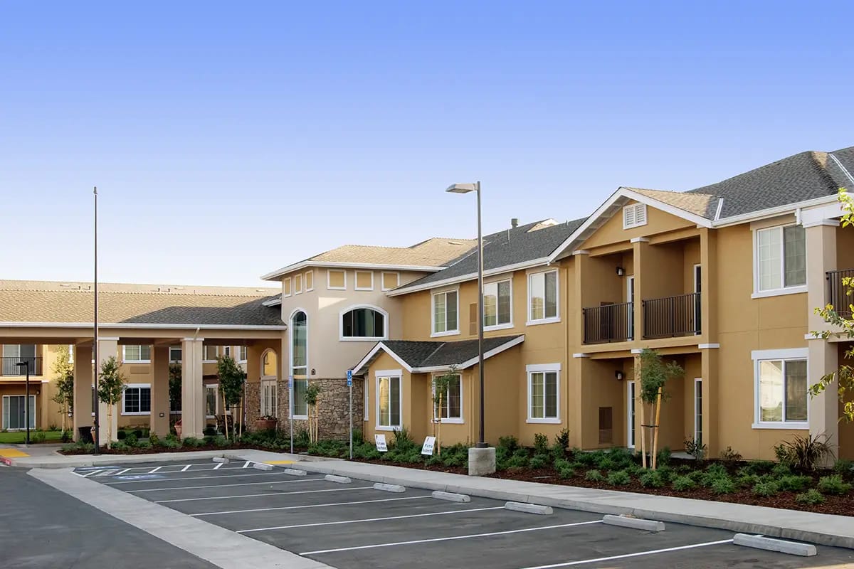 Exterior view of a senior living facility with parking