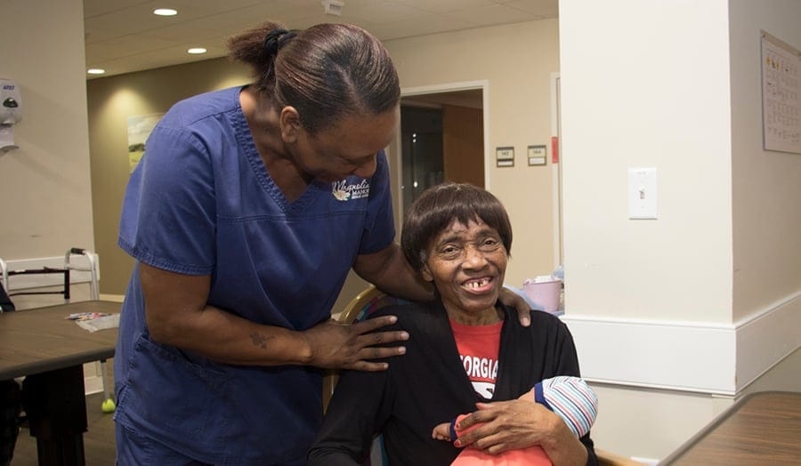 Staff assisting a resident in a facility common area