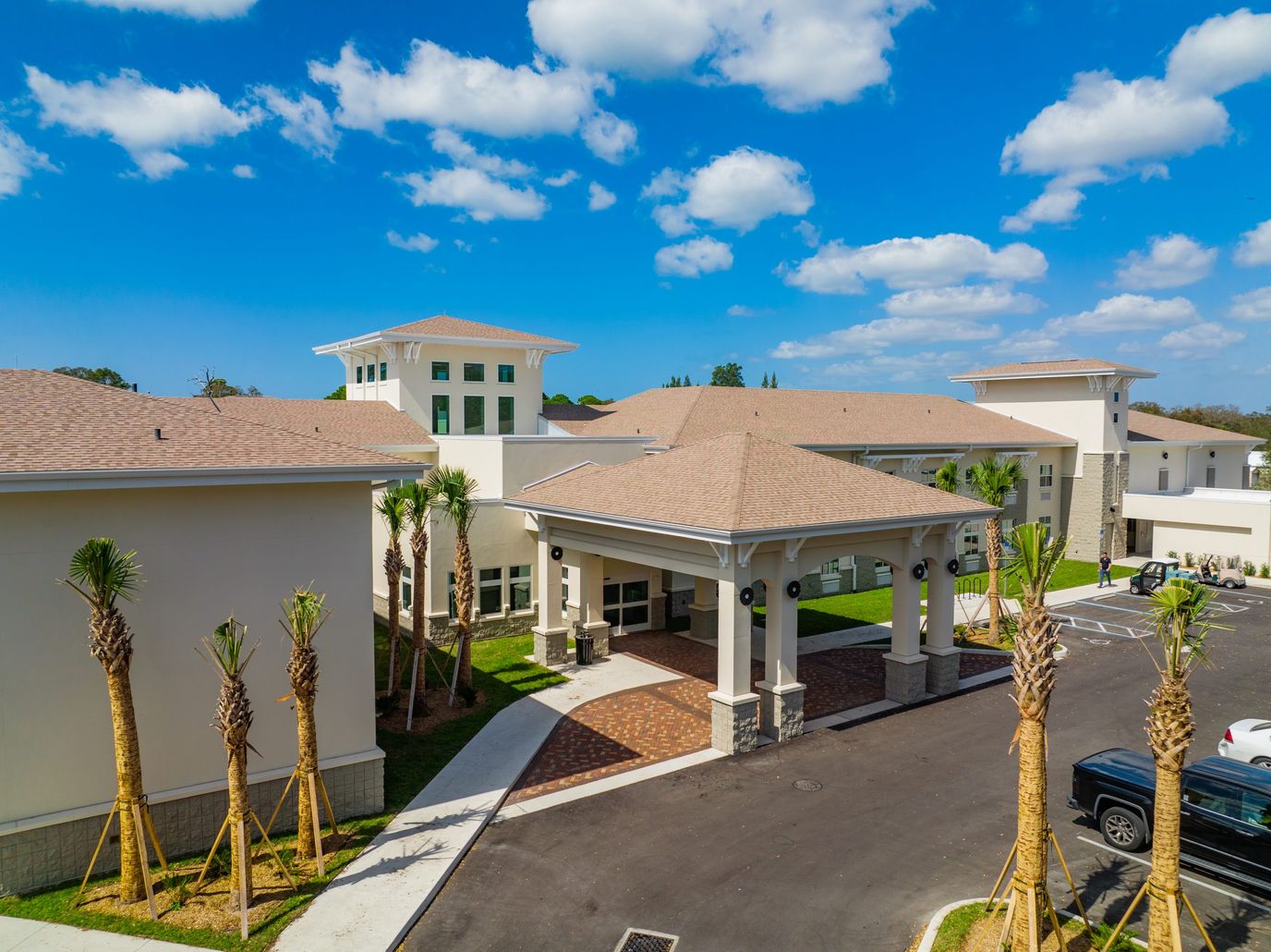 Exterior view of a senior living facility with palm trees