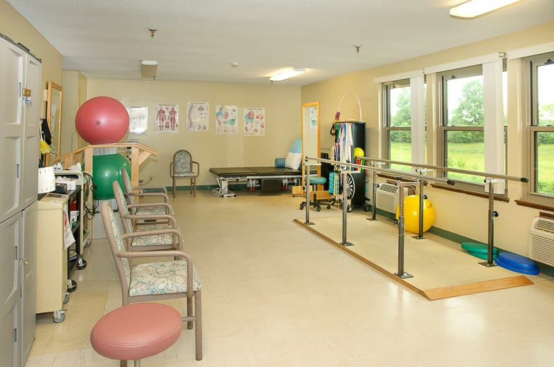 Physical therapy room with exercise equipment and seating