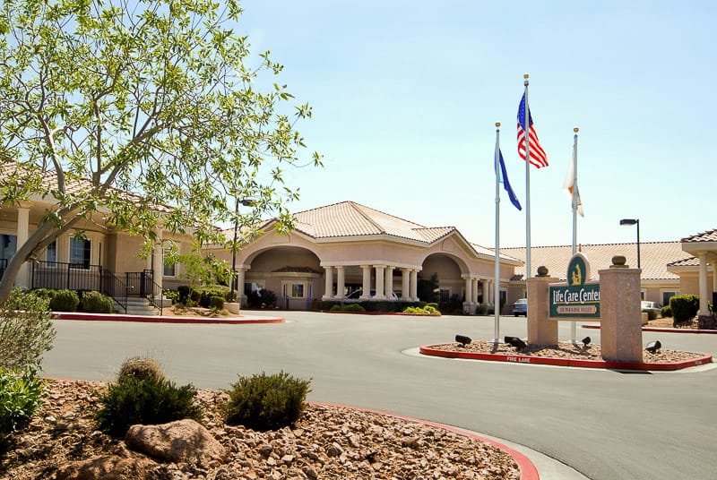 Exterior view of Life Care Center with flags and landscaping