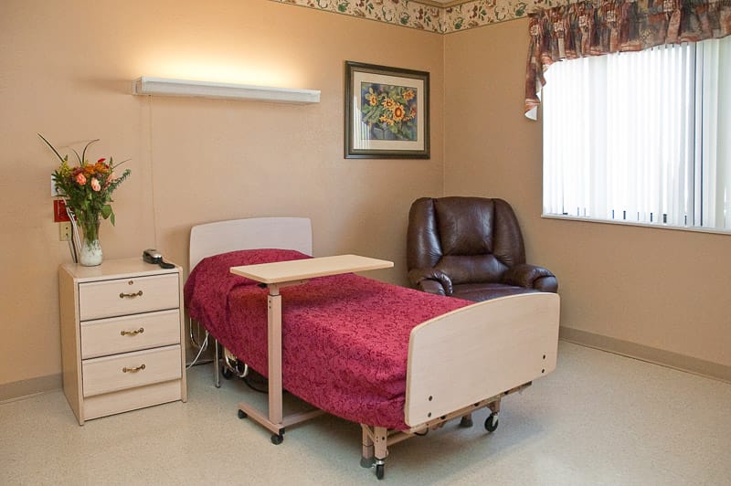 A single resident room with decorated walls and a bed
