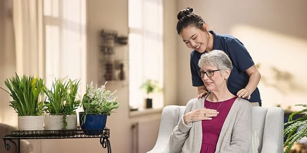 Caregiver assisting a senior resident indoors.