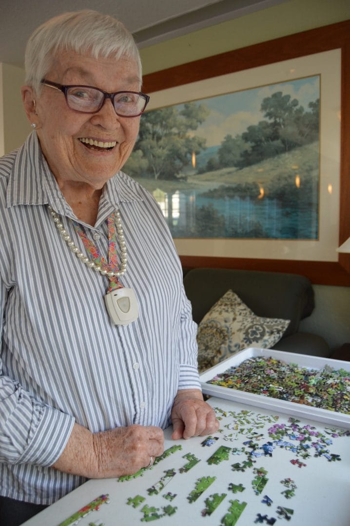 Resident engaged in a puzzle activity with a smile