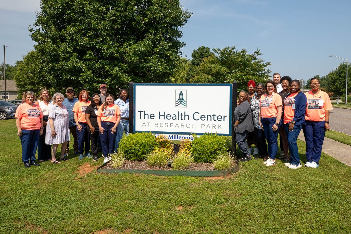 Group photo of staff in front of the facility sign