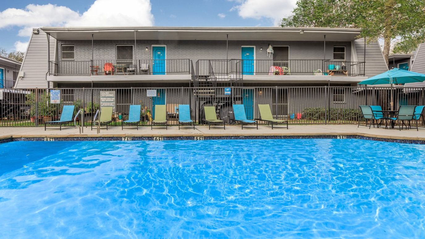 Building exterior with a pool and seating area
