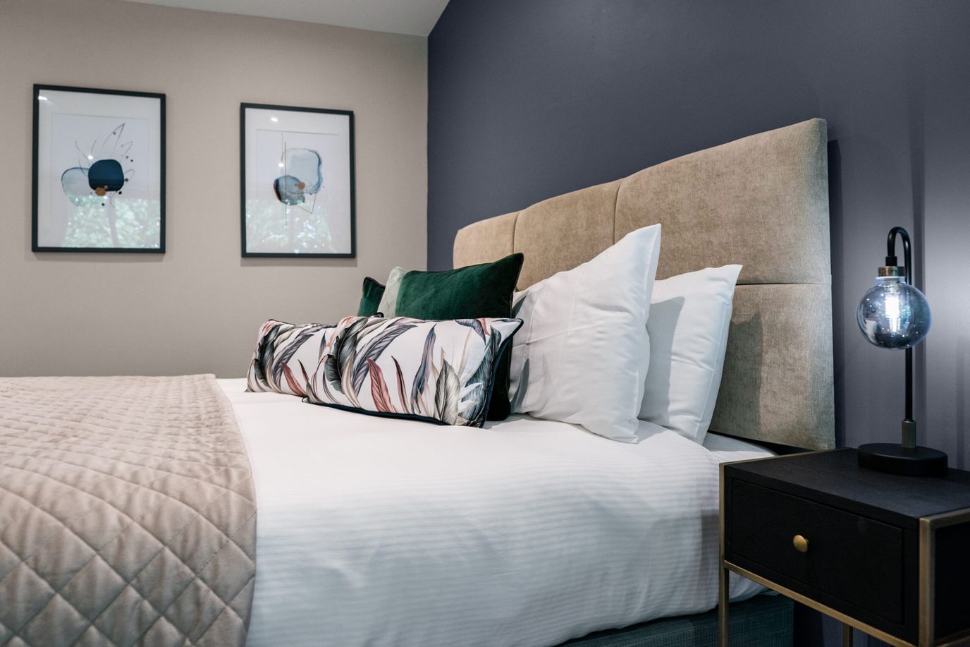 A well-decorated interior room with a bed and artwork