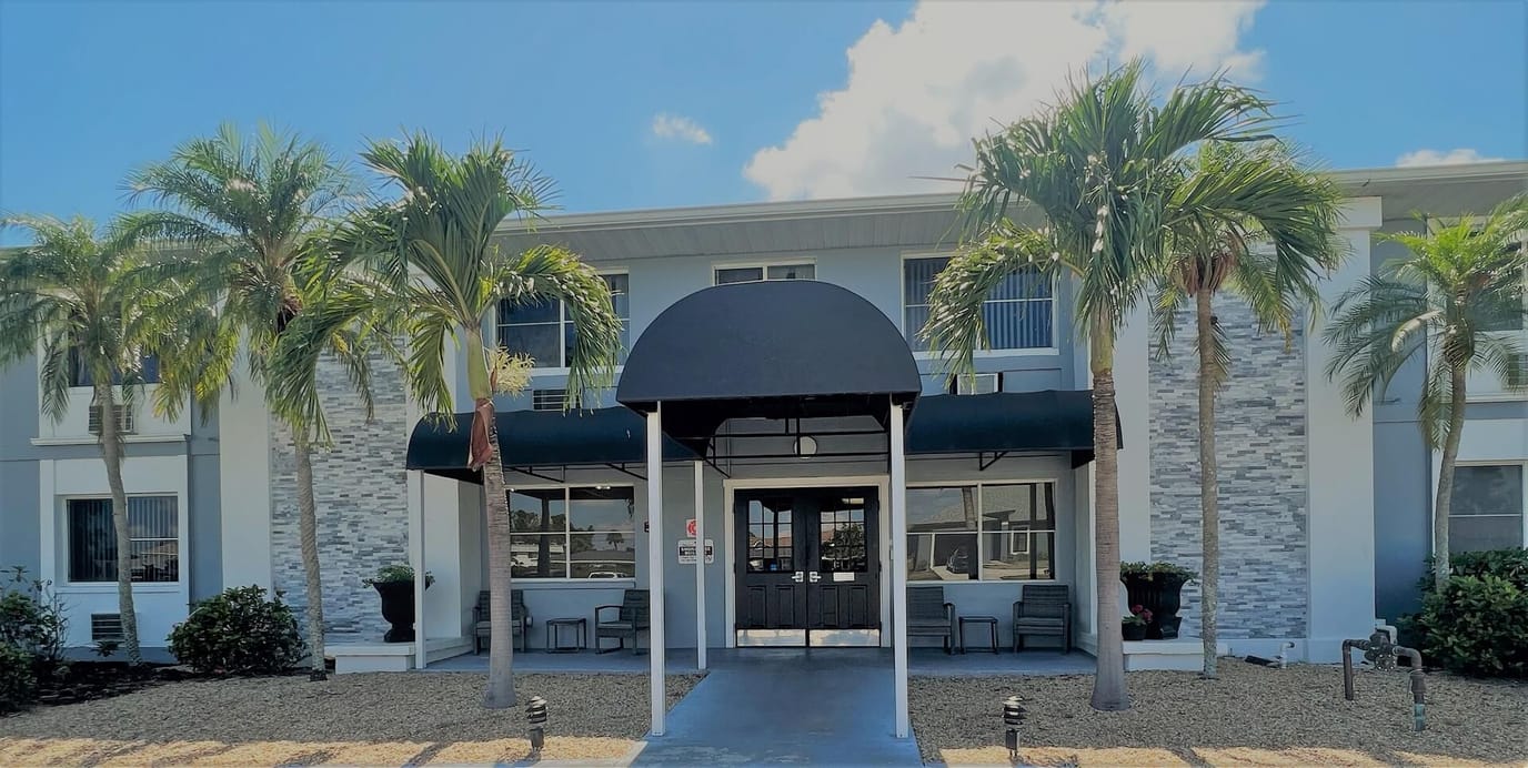 Front entrance of The Elite ALF with palm trees