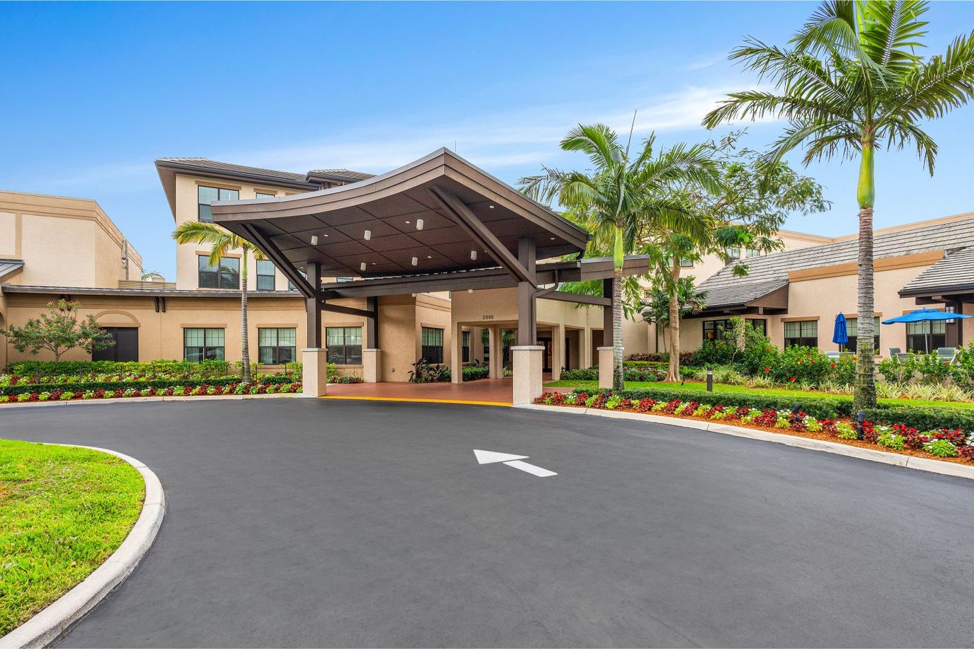 Entrance to The Cascades at Delray Senior Living with landscaped area