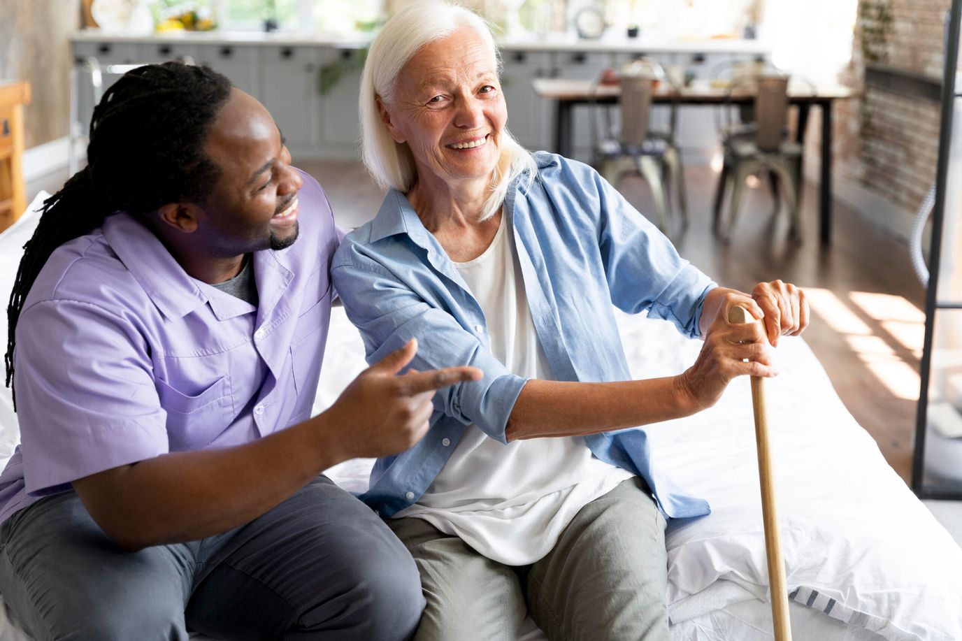 A caregiver and resident smiling together in a cozy room