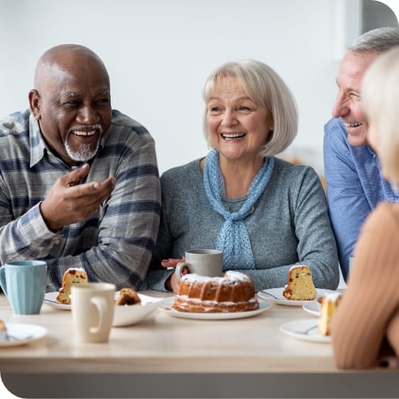 Residents enjoying dessert and conversation at a table.
