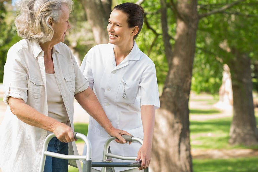 Nurse assisting a resident outdoors