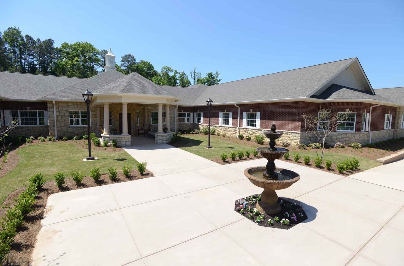 Exterior view of the facility with landscaping and fountain