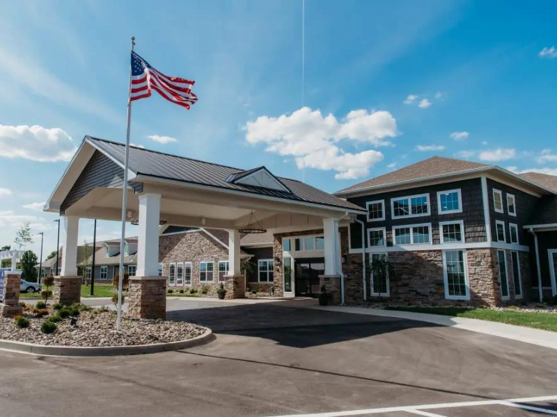 Entrance of a senior living facility with American flag