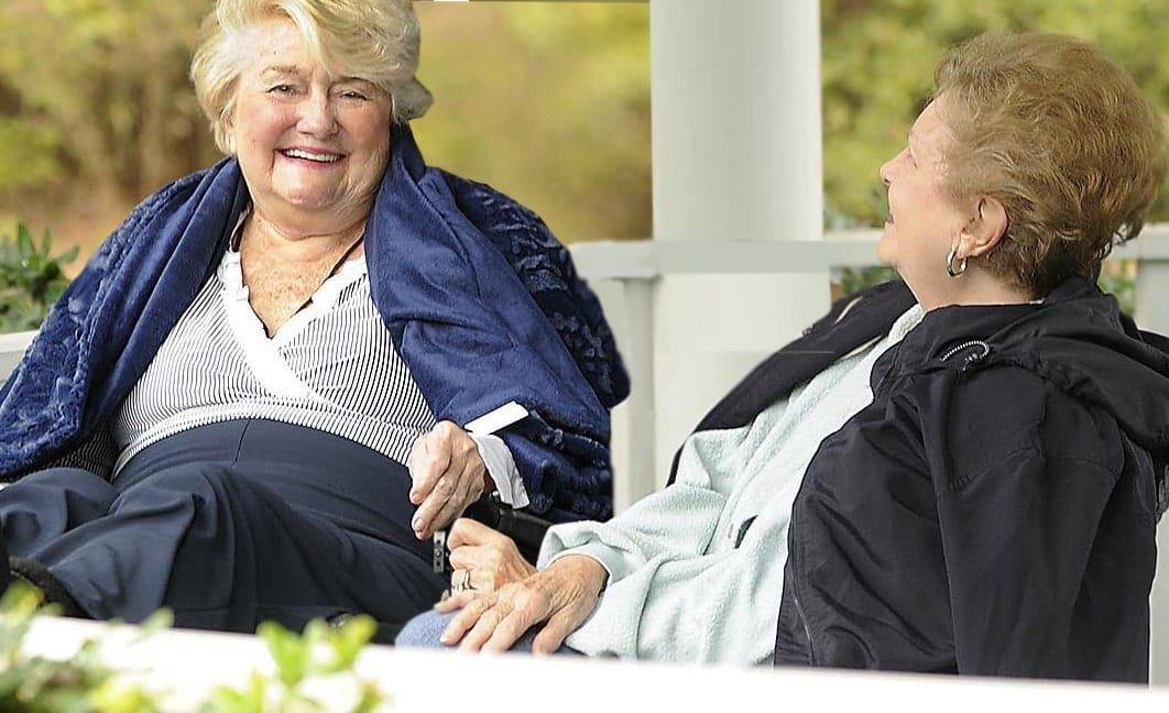Two smiling residents enjoying time together outdoors
