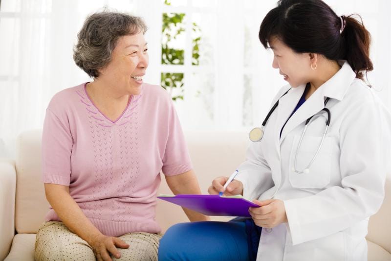 Doctor consulting with smiling senior resident.