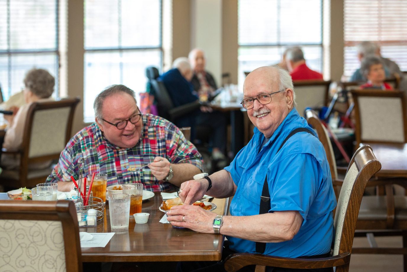 Two residents enjoying a meal in the dining room.