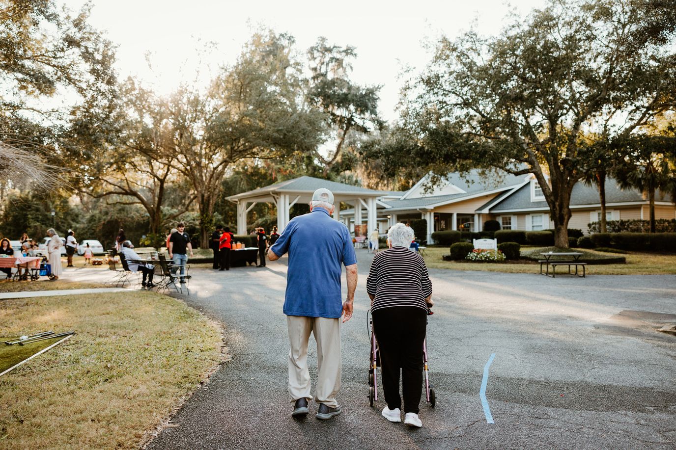 Elderly couple walking in the outdoor area of the facility.