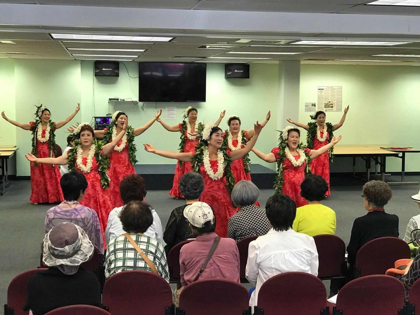 Residents enjoying a hula performance in a common area