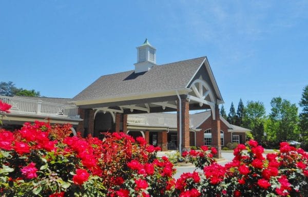 Exterior view of a senior living facility with blooming roses