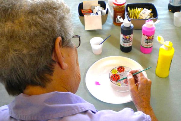 Senior resident painting during an art activity