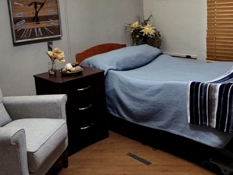 Cozy interior of a resident room with a bed and chair