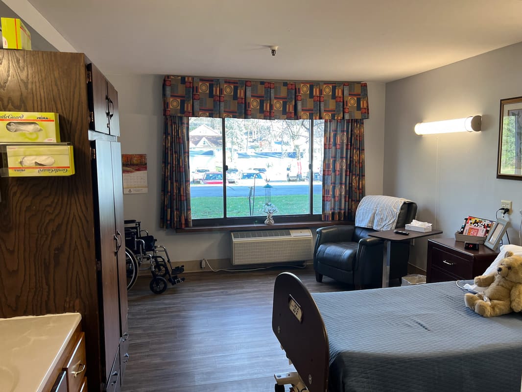Cozy resident room with a view and sitting area.