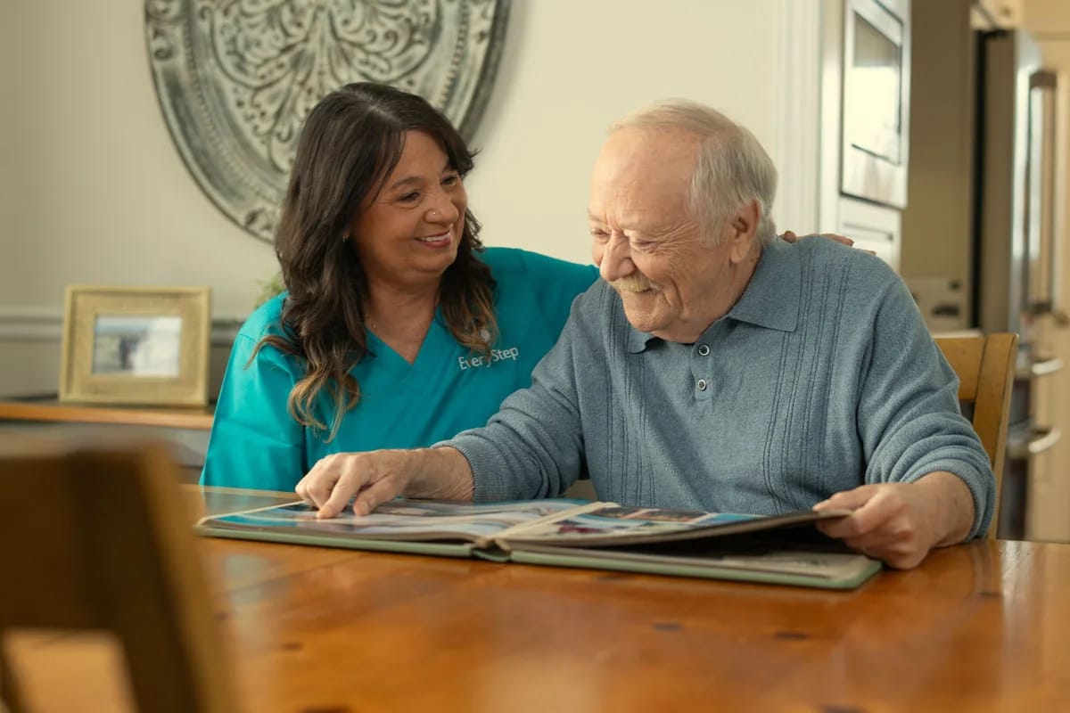 A caregiver assisting a resident with a photo album