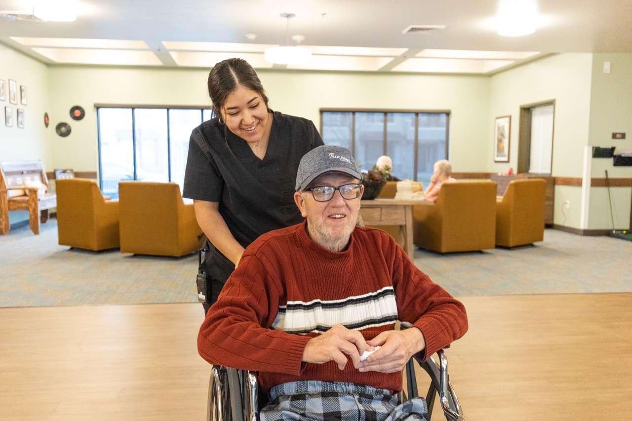 A staff member assisting a resident in a common area