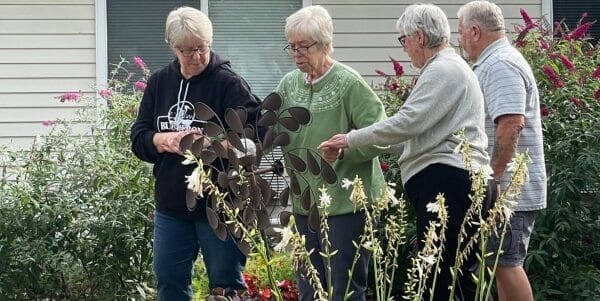 Residents engaging with a garden feature outdoors
