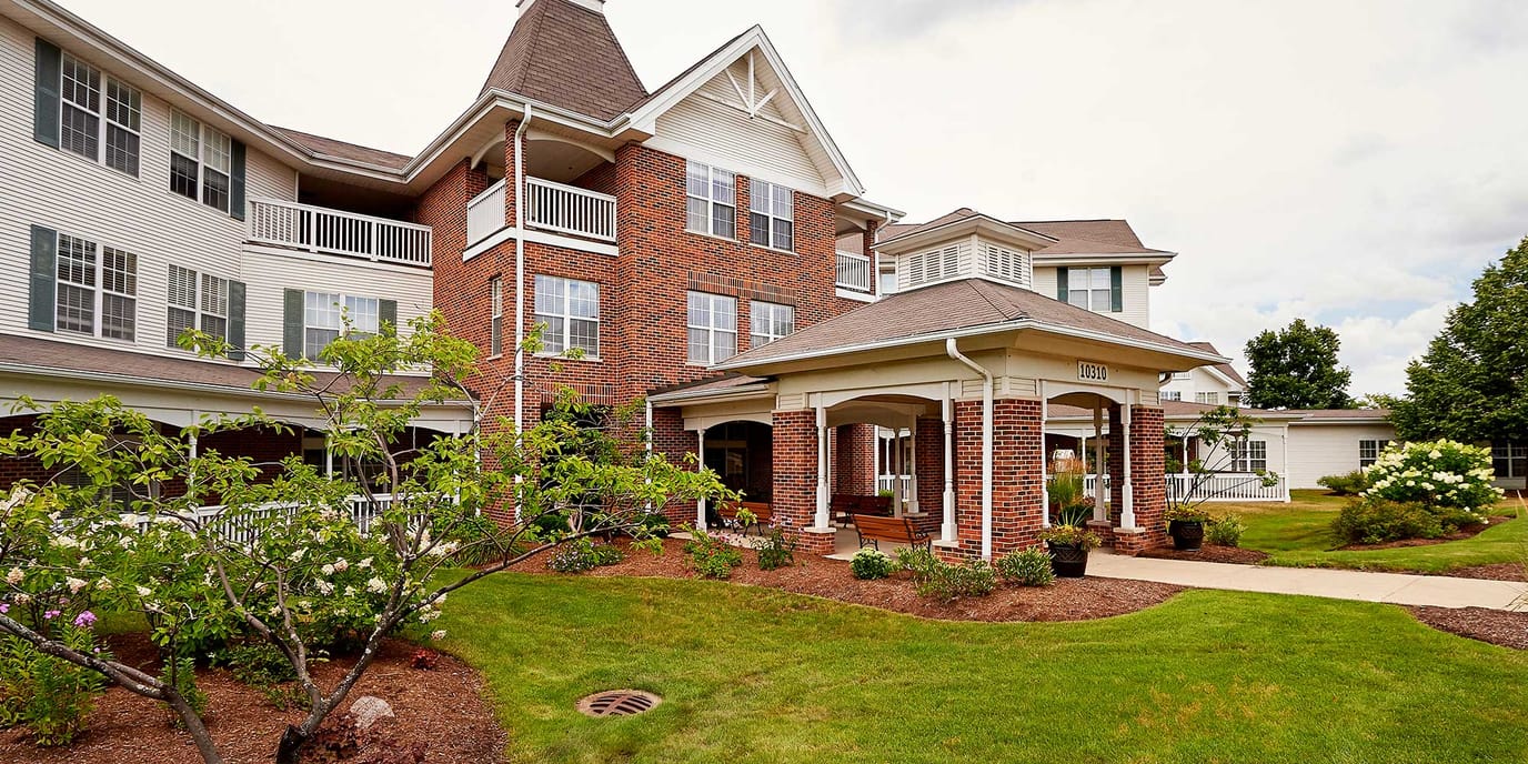 Exterior view of a senior living facility with gardens