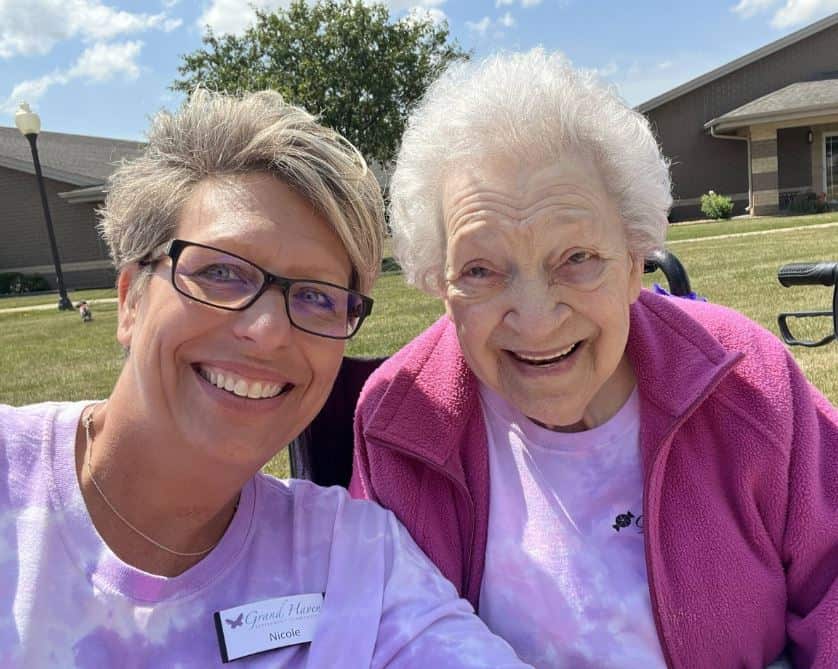 Staff member and resident smiling outdoors in the community