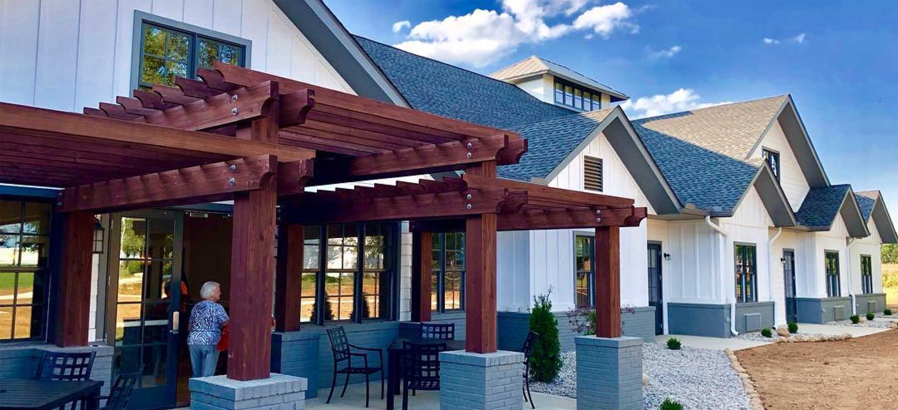 Exterior view of a senior living facility with outdoor seating