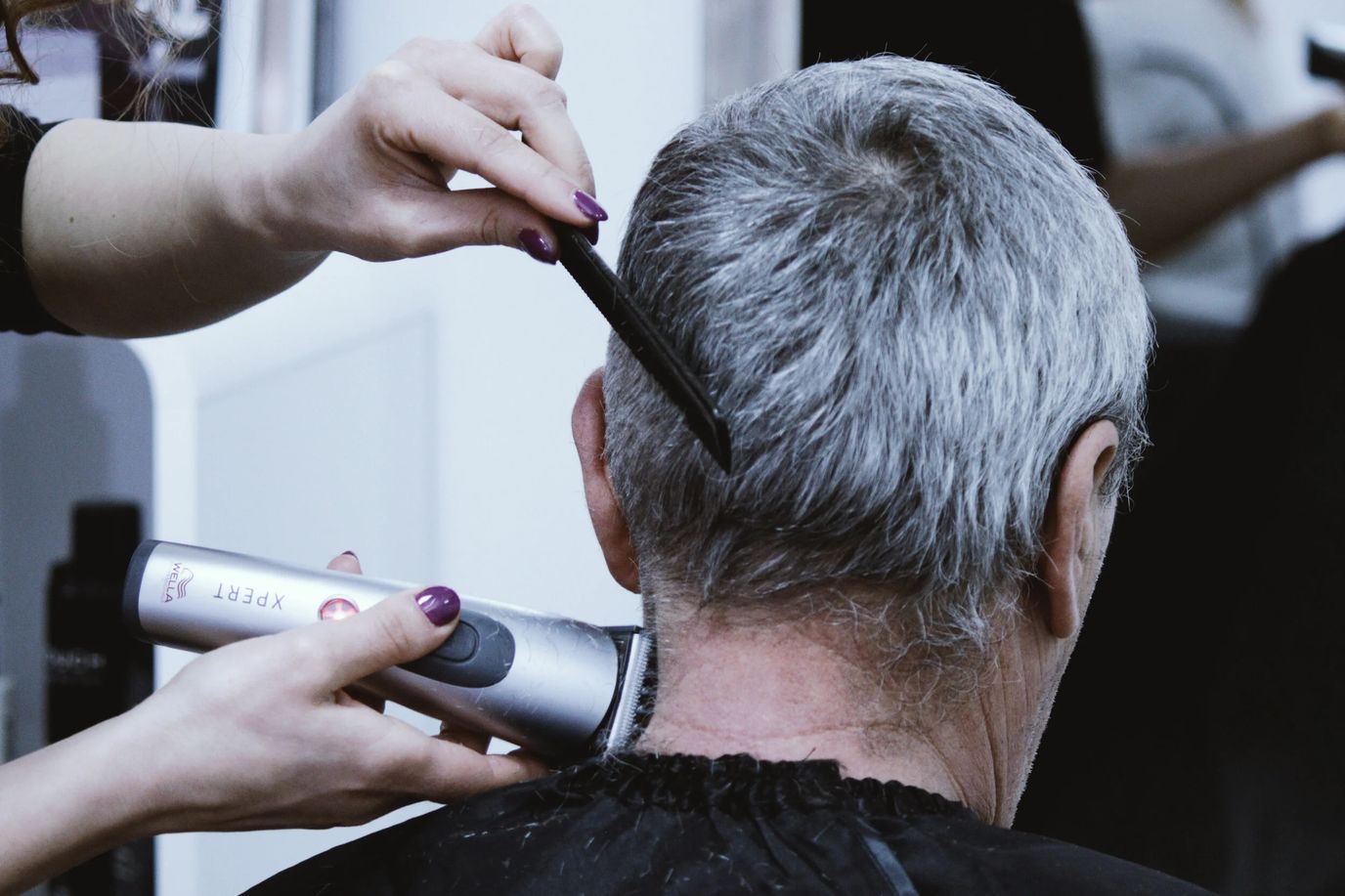 A person receiving a haircut at a salon