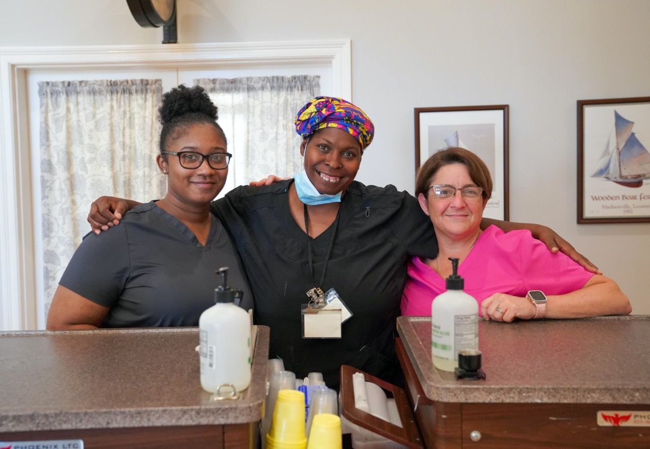 Three staff members smiling in a facility interior