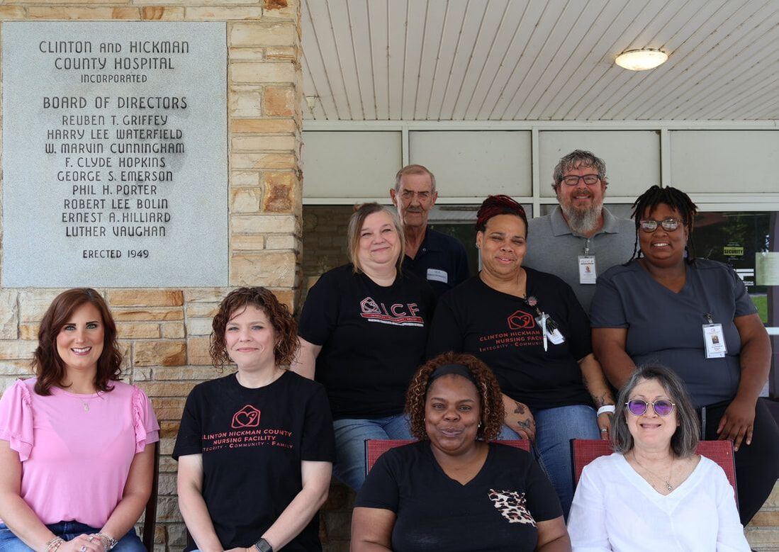 Staff members posing outside the facility entrance
