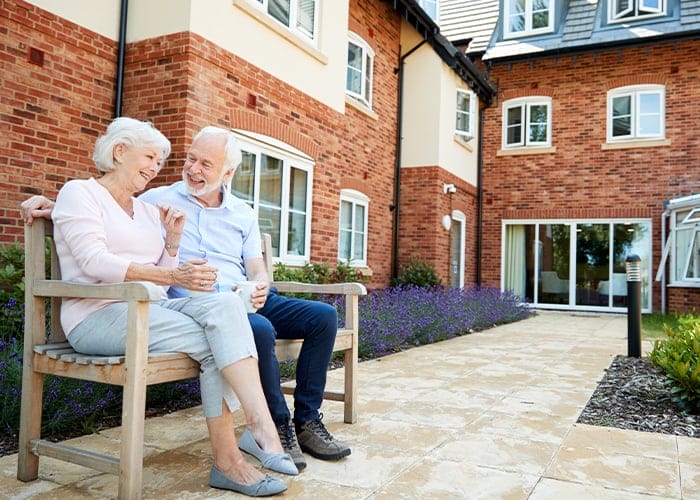 Seniors enjoying a conversation on a bench outside