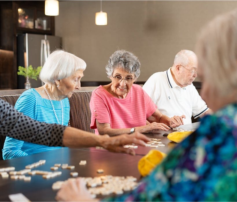 Residents enjoying a game of tiles in a common area