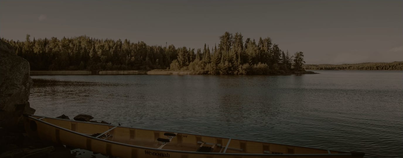 Canoe on a calm lake surrounded by trees